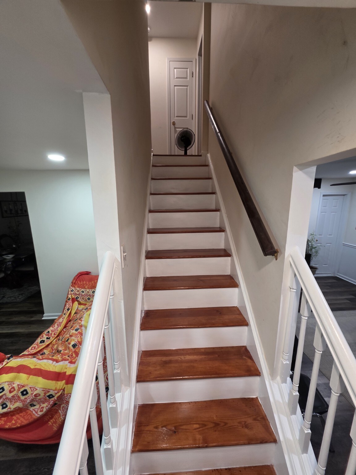Wood staircase refinishing project with white risers
