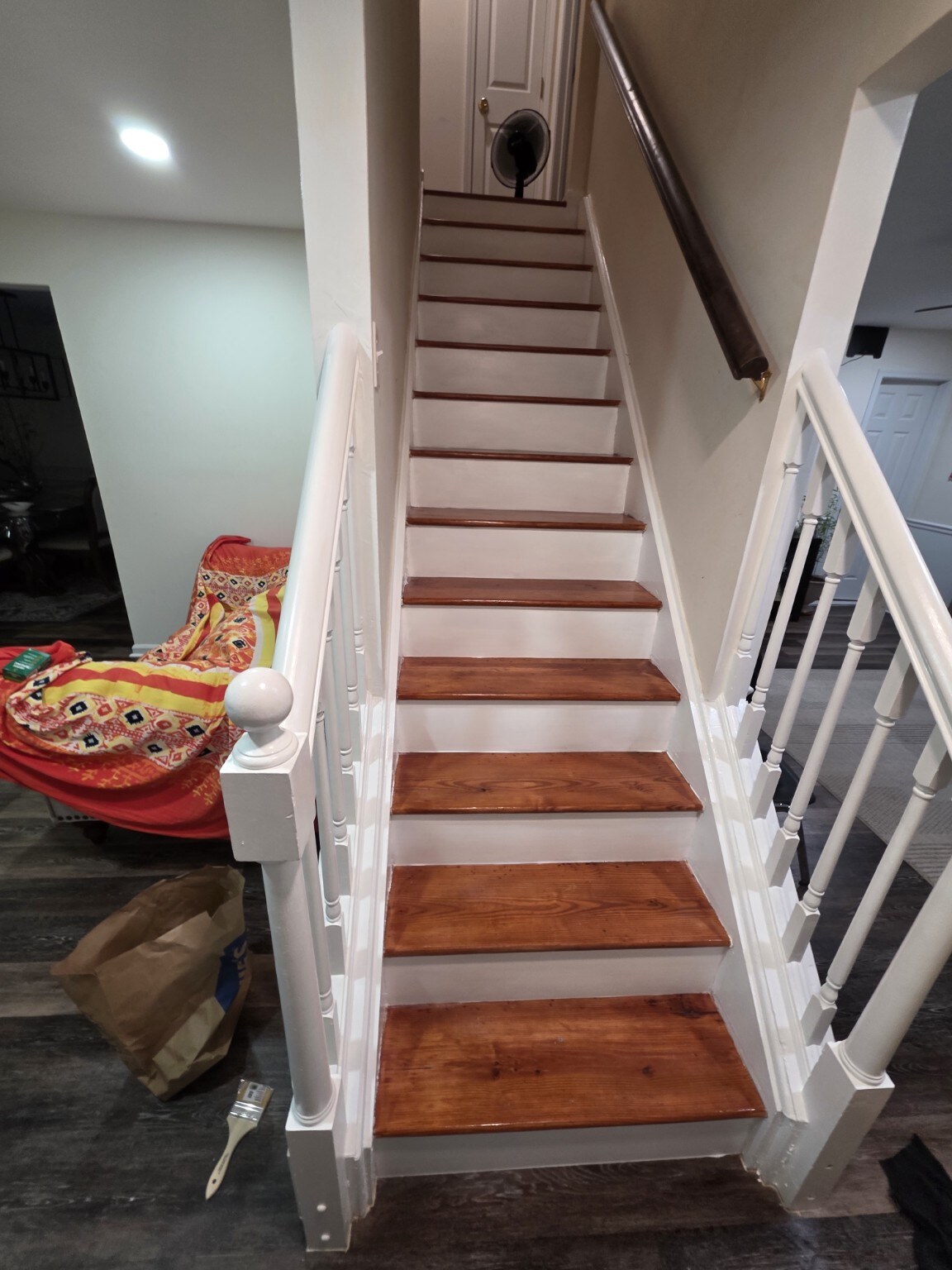 Completed stained wood staircase with white balusters